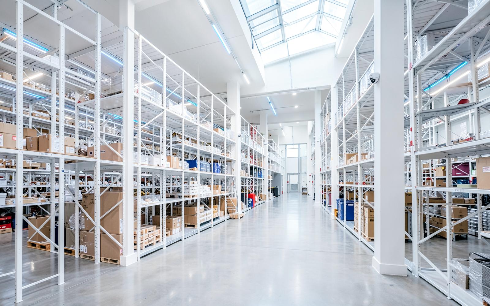 Interior of a large modern warehouse with racking aisles monitored by security cameras